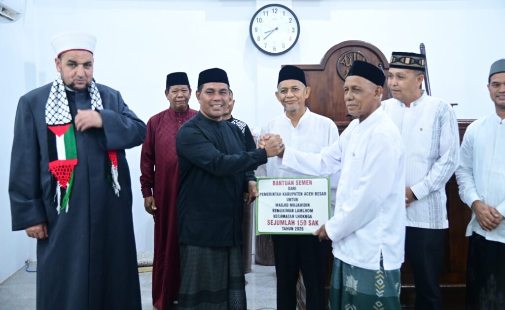 Bupati Aceh Besar H Muharram Idris yang akrab disapa Syech Muharram menyerahkan bantuan 150 sak semen secara simbolis kepada Jufri AR selaku Imuem Mukim Lamlhom dalam Safari Ramadhan tahun 1446 H di Masjid Mujahidin Kemukiman Lamlhom Kecamatan Lhoknga Kabupaten Aceh Besar Sabtu 832025 malam FOTO MC ACEH BESAR