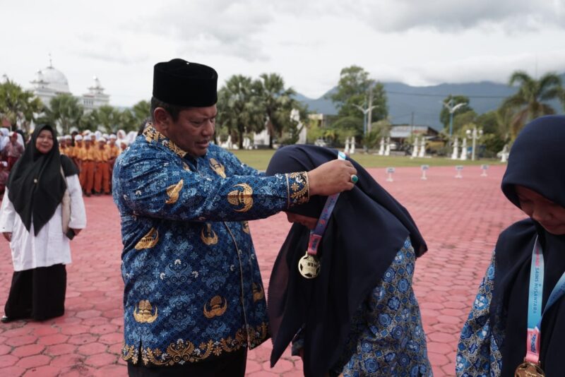 Sekda Aceh Besar Bahrul Jamil SSos MSi menyerahkan piagam penghargaan kepada siswa yang berprestasi pada peringatan Hari Anak Nasional ke 41 tahun 2025 di halaman Kantor Bupati Aceh Besar Rabu 2372025 FOTOMC ACEH BESAR