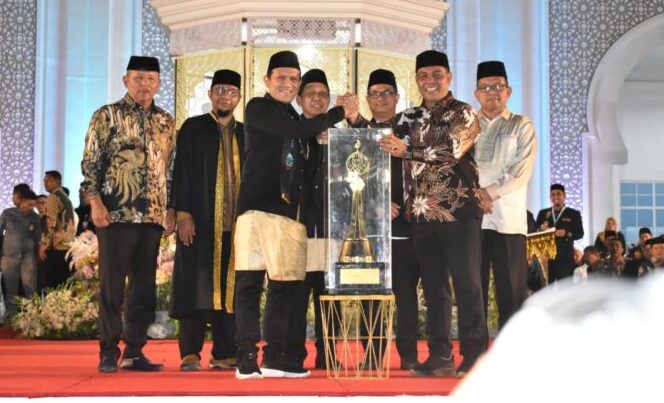 Wakil Gubernur Aceh Fadhlullah SE menyerahkan Piala Juara Umum kepada Bupati Aceh Besar H Muharram Idris Syeh Muharram pada acara Penutupan Musabaqah Tilawatil Quran MTQ Aceh ke37 yang digelar di Kabupaten Pidie Jaya pada Jumat malam 7 November 2025 KETIKKABARcom Wakil Gubernur Aceh Fadhlullah SE menyerahkan Piala Juara Umum kepada Bupati Aceh Besar H Muharram Idris Syeh Muharram pada acara Penutupan Musabaqah Tilawatil Quran MTQ Aceh ke 37 yang digelar di Kabupaten Pidie Jaya pada Jumat malam 7 November 2025