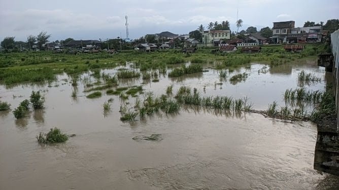 Luapan air mulai merendam area bantaran sungai dan membuat aliran tampak melebar Kamis 27112025 Foto MirzaKETIKKABARcom