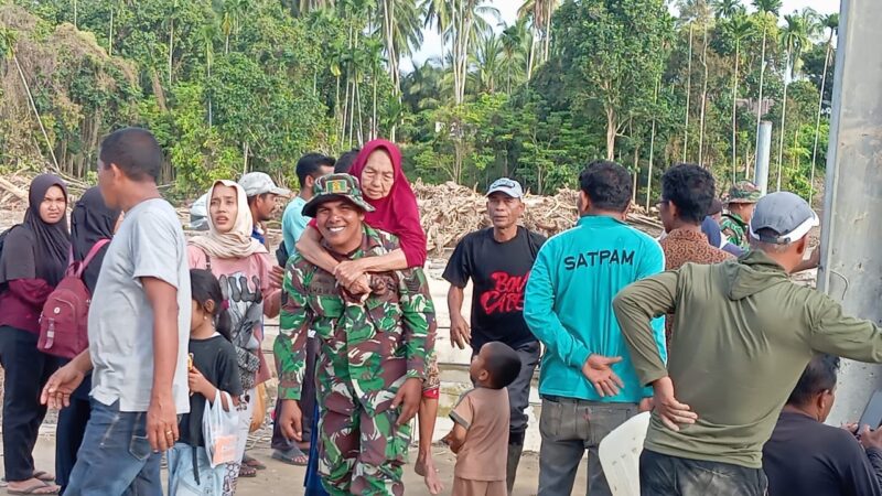 seorang prajurit TNI Serma Ilham Babinsa Kodim 0111Bireuen menggendong seorang ibu lansia usai melintasi tumpukan puing kayu besar dan material banjir yang berserakan di Desa Awe Geutah Kecamatan Peusangan Siblah Krueng Kabupaten Bireuen pada Selasa 2122025